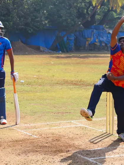 A young bowler learning his craft during a practice match, with a batsman ready to face the challenge.
