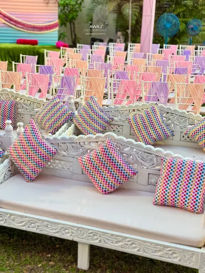 Close-up of the traditional carved white benches with colorful patterned cushions, adding a touch of Indian heritage.