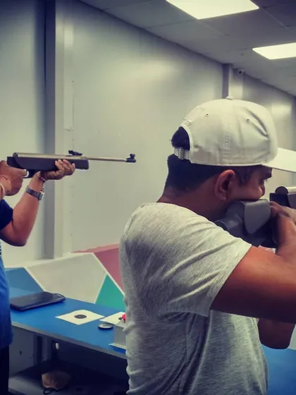 Two guests deeply focused during their target practice. You can see the concentration required to hold the rifle steady and aim for the bullseye.