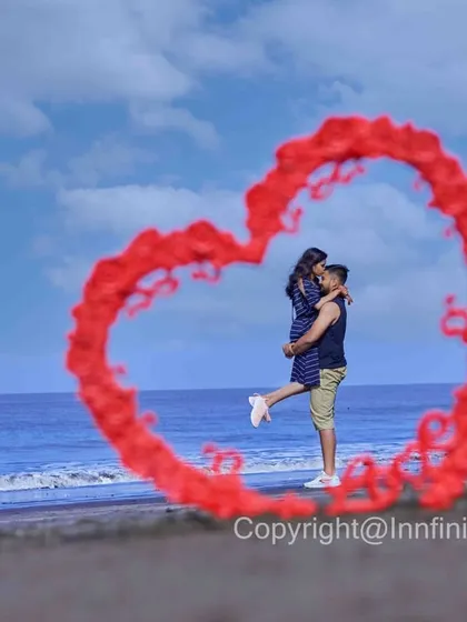 A creative beach shot where we use red smoke to form a heart shape around the couple, making for a unique and memorable pre-wedding photo.