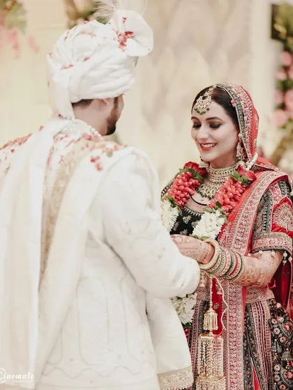 A beautiful moment during the wedding ceremony, capturing the couple's interaction and the intricate details of their traditional attire.