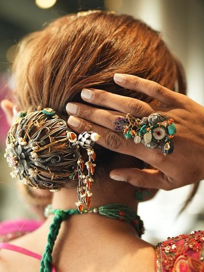 A behind-the-scenes shot from a creative collaboration. This image focuses on the intricate hair bun and statement jewelry, showing how we build a look from every angle.