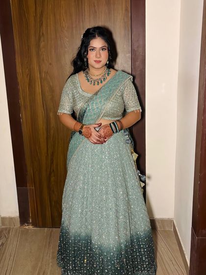 A stunning party look in a pastel blue lehenga. The makeup features a soft smokey eye and nude lips.