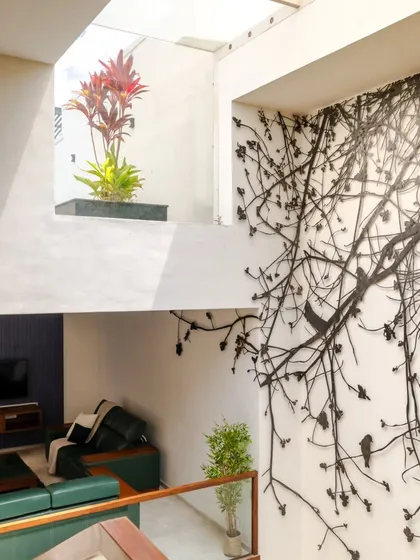 I believe in blurring the lines between indoors and outdoors. This central courtyard brings light and nature into the very heart of the home, seen here next to a custom metal art installation inspired by the Tree of Life. The space acts as the home's green lung, connecting every level with nature.