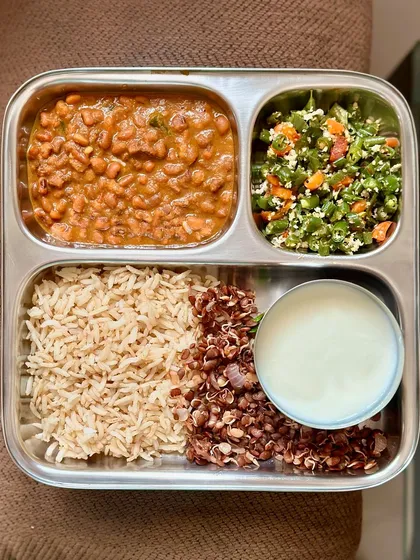 A plate with brown rice, cowpea curry, horse gram sundal, sautéed beans, and curd. This meal is packed with different types of legumes for a protein and fiber boost.