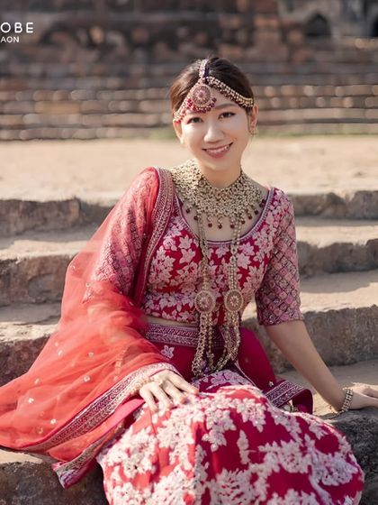 Embracing Indian tradition with grace. This client looks absolutely radiant sitting in her rented red and pink embroidered lehenga, complete with stunning jewellery.