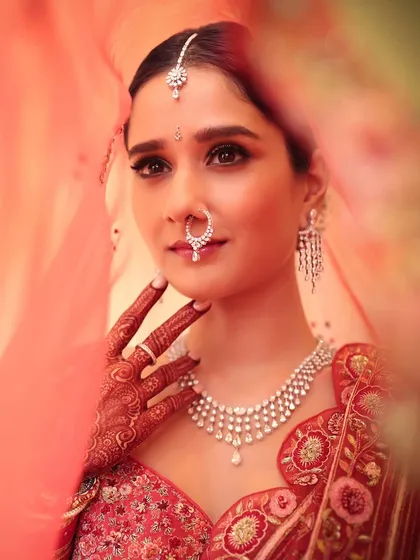 A classic red bridal look will always be iconic. Peeking through the veil, this shot captures the soft yet regal glam I created for her, focusing on elegant eyes and a finish that feels both traditional and modern.