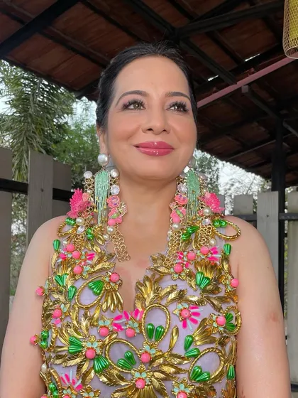 The front view of the client with the carnival ponytail. Even a simple updo can be a statement when paired with such fun accessories and a vibrant outfit.