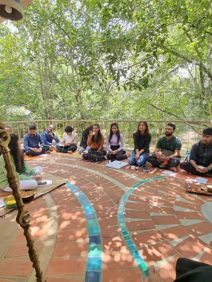 Under the shade of the trees, the tiled patio becomes an informal gathering spot. This space embodies the principle of integrated indoor-outdoor living, providing a place for community and connection with nature.
