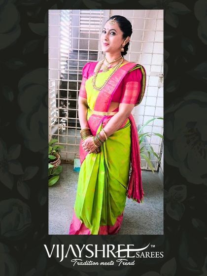 Anju Sathish looking vibrant in a parrot green and pink Kanjivaram, styled traditionally for a festive look.
