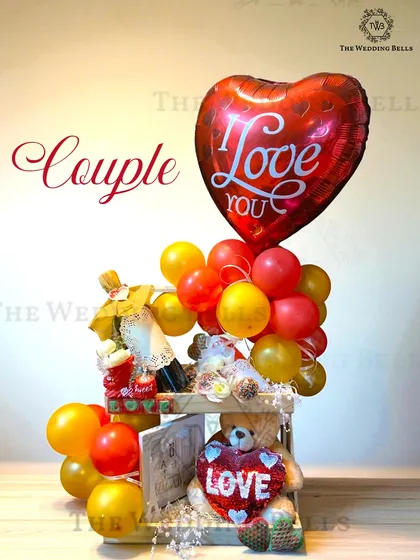 Love, wrapped in a hamper. This couple's hamper with a teddy bear, a mini wine bottle, and a heart-shaped balloon is perfect for an anniversary or just because.