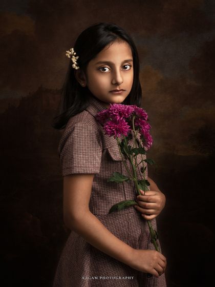 A slightly different angle of the girl with flowers, this fine art portrait is a stunning example of capturing a child's quiet grace.