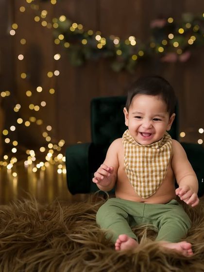 A whole lot of personality. This little boy's infectious laugh fills the studio during his sitter session, set against a magical backdrop of twinkling lights.