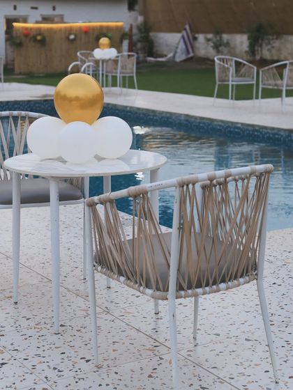Simple and elegant poolside seating. This is a great spot to enjoy a drink or a snack after a swim, with balloons adding a touch of celebration to the air.