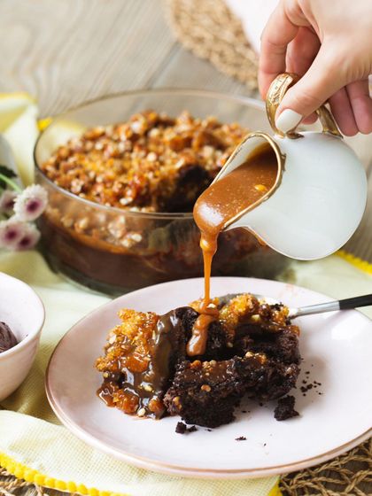 The ultimate indulgence. I'm pouring warm, homemade salted caramel sauce over a serving of my chocolate trifle, which is layered with dark chocolate cake and crunchy almond praline.