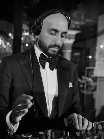 A black and white shot of me focused on the decks during a wedding in Marrakech. Even in the most beautiful locations, the music is always the priority.