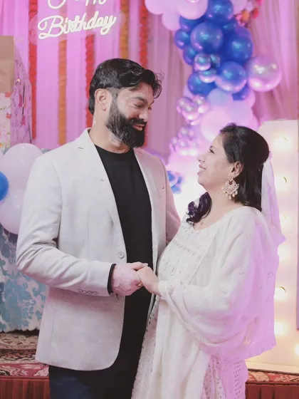 A loving glance between parents during their son's first birthday celebration. These are the candid moments that tell the story of your family's love.