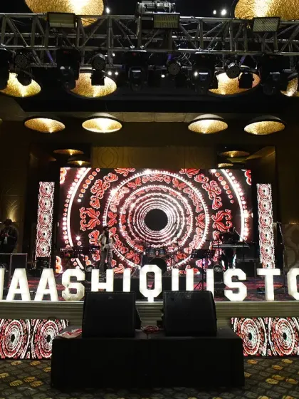 The stage is set for a night of performances and celebration. We integrate personalized elements like this custom LED hashtag sign for the couple, making their story the focal point of the Sangeet night's entertainment.
