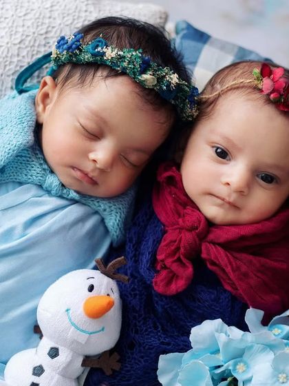 A closer look at our little Anna and Elsa. One is sleeping soundly while her sister peeks at the camera. Capturing these little moments of individuality is so important in a twin photoshoot.