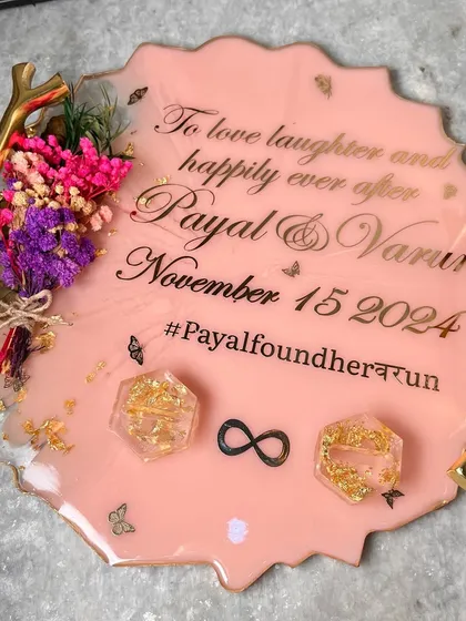 A lovely peach-colored ring tray with elegant gold branch handles. It's personalized with the couple's names, date, and a custom hashtag.