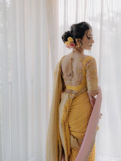 A view of the intricate hairstyle and back of the blouse, showing the complete bridal look.