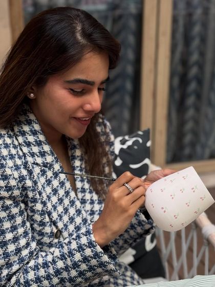 A guest enjoying the therapeutic process of painting her mug with a delicate pattern at our pop-up workshop.