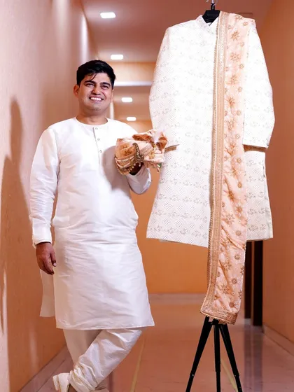 The groom posing with his wedding sherwani. This "getting ready" shot builds anticipation for the main event.