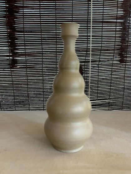 A collection of large, unglazed vases in various shapes and sizes. Each one is thrown on the wheel and showcases a different form, from classic curves to textured surfaces.