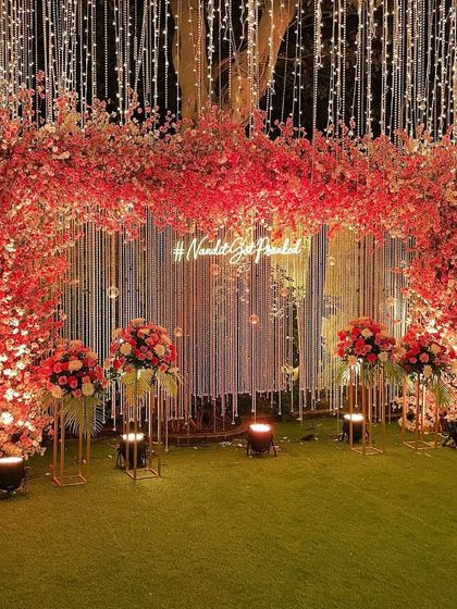 A stunning cherry blossom themed backdrop. We used shades of pink and red, along with a custom neon hashtag, to create this vibrant and modern photo-op for an engagement.