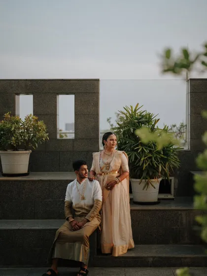 A modern take on a traditional portrait. The couple is posed against a contemporary stone wall, blending classic attire with a modern architectural setting for a unique and stylish look.
