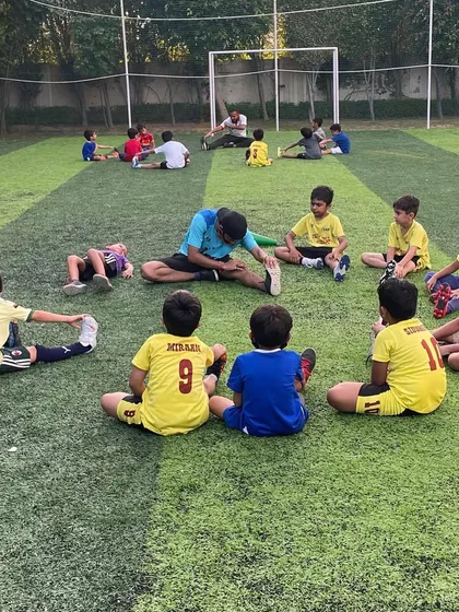 Players stretching in a circle. We believe in the power of unity and collective growth, supporting each other every step of the way.