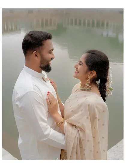 A happy, natural shot of a couple sharing a laugh by the temple pond, reflecting their easy chemistry.