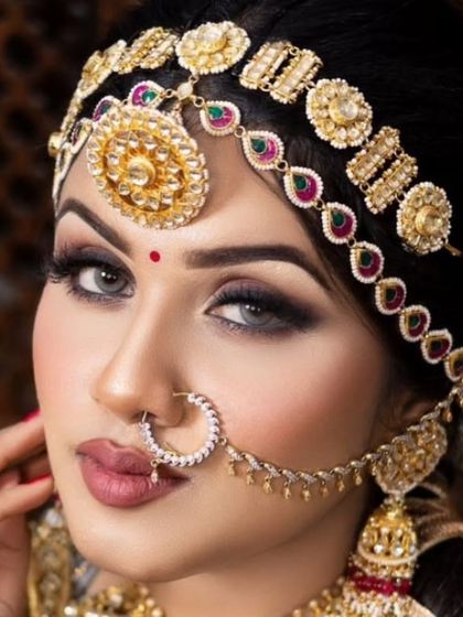 A close-up shot of a bride's face, highlighting a beautiful Kundan mathapatti and nath. This shows the intricate detail of my headpieces.