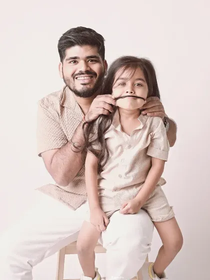 A funny-face moment. This father-daughter portrait, with her hair as a mustache, is a perfect example of their playful relationship.