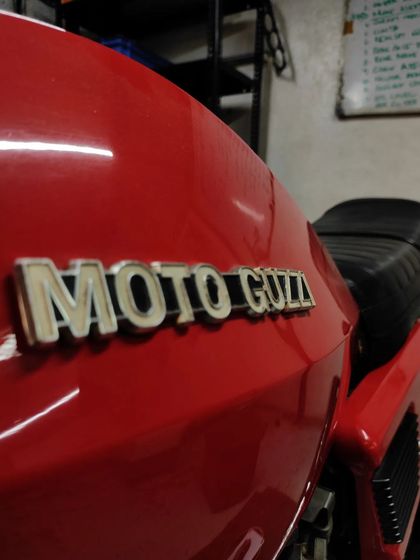 Close-up on the Moto Guzzi tank logo.