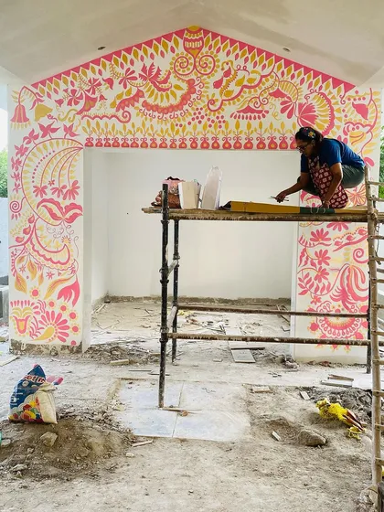Perched on the scaffolding, I'm filling in the upper sections of the 'Baba's Garden' mural. Working on a large scale like this is physically demanding but so rewarding when you see the art transform the entire structure.