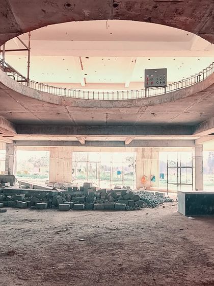 A raw construction site photo showing a large circular cutout in the concrete slab, a moment of pure geometry that will later become a key architectural feature.