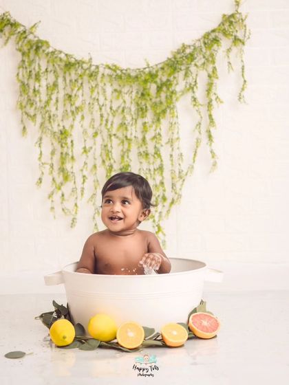 Look at that happy smile. A citrus-themed milk bath with bright lemons and grapefruit slices creates such a cheerful and refreshing scene.