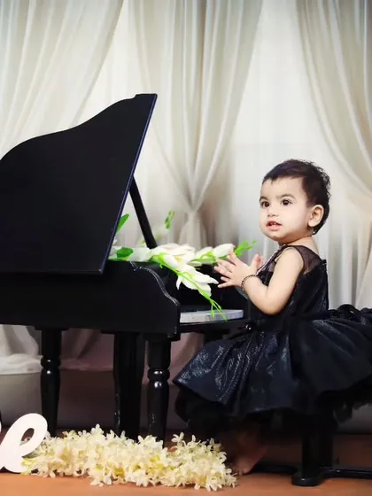 The birthday girl claps her hands with joy during her piano-themed session.