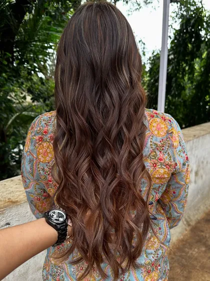Getting her holiday-ready with a rich blend of copper and caramel highlights. This warm, wavy style is perfect for a festive getaway.