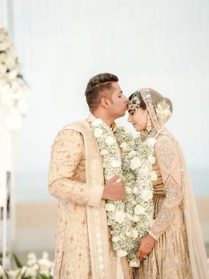An intimate and tender moment between the couple. The groom kisses his bride's forehead during their beautiful Goa wedding ceremony, a perfect picture of love and commitment.
