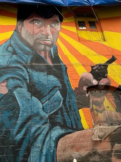 A larger-than-life mural of a Bollywood hero, capturing the dramatic and colorful style of the city's street art.