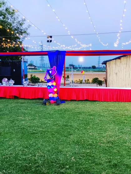 For outdoor birthday parties, we set up extensive buffet counters. This long table is draped in red and blue fabric to match the Spiderman theme, with string lights overhead for evening ambiance.