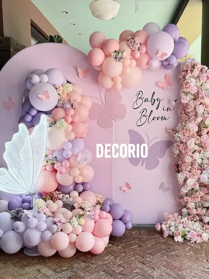 This "Baby in Bloom" butterfly theme is one of my most requested designs for baby showers. I use a custom-arched backdrop, a lush organic balloon garland in pastel pinks and purples, and delicate butterfly accents to create a truly magical photo corner.