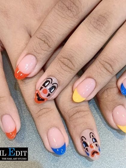Express every mood with this unique hand-painted clown face design. Paired with colorful French tips, this quirky and artistic set is for those who want their nails to be a conversation starter.
