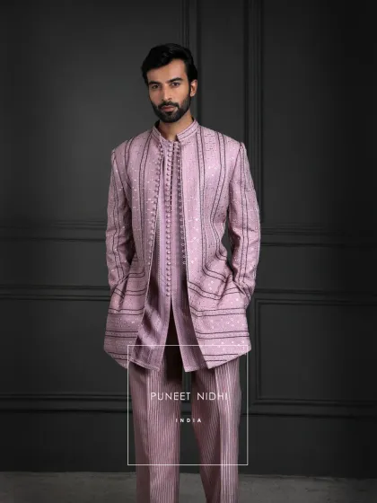 Dusty salmon pink with a subtle sheen, where every fold speaks of grace. This silk blend drapes with richness, adorned with looped buttons and woven stripes.