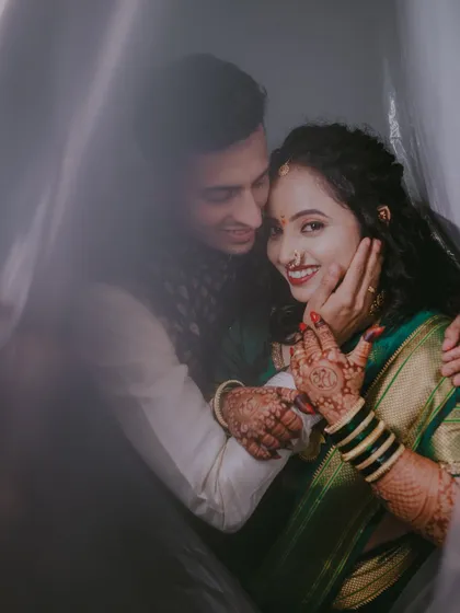 A creative shot taken through a sheer curtain, which adds a soft, dreamy quality to the image. This technique creates a sense of intimacy, as if we are getting a private glimpse of their happiness.