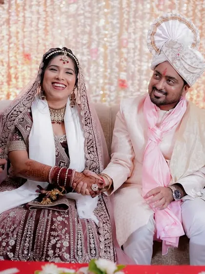 A candid shot of the couple sharing a laugh with a guest during their wedding ceremony.