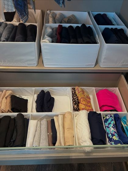 A combination of open bins and drawer dividers creates a highly customized storage solution for different types of clothing.