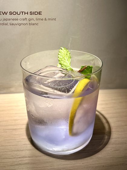 The New South Side, a refreshing gin cocktail with a twist. Roku gin, lime, mint, and a splash of Sauvignon Blanc create a crisp and aromatic drink.